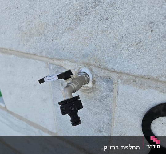 ברז מים מותקן על קיר אבן